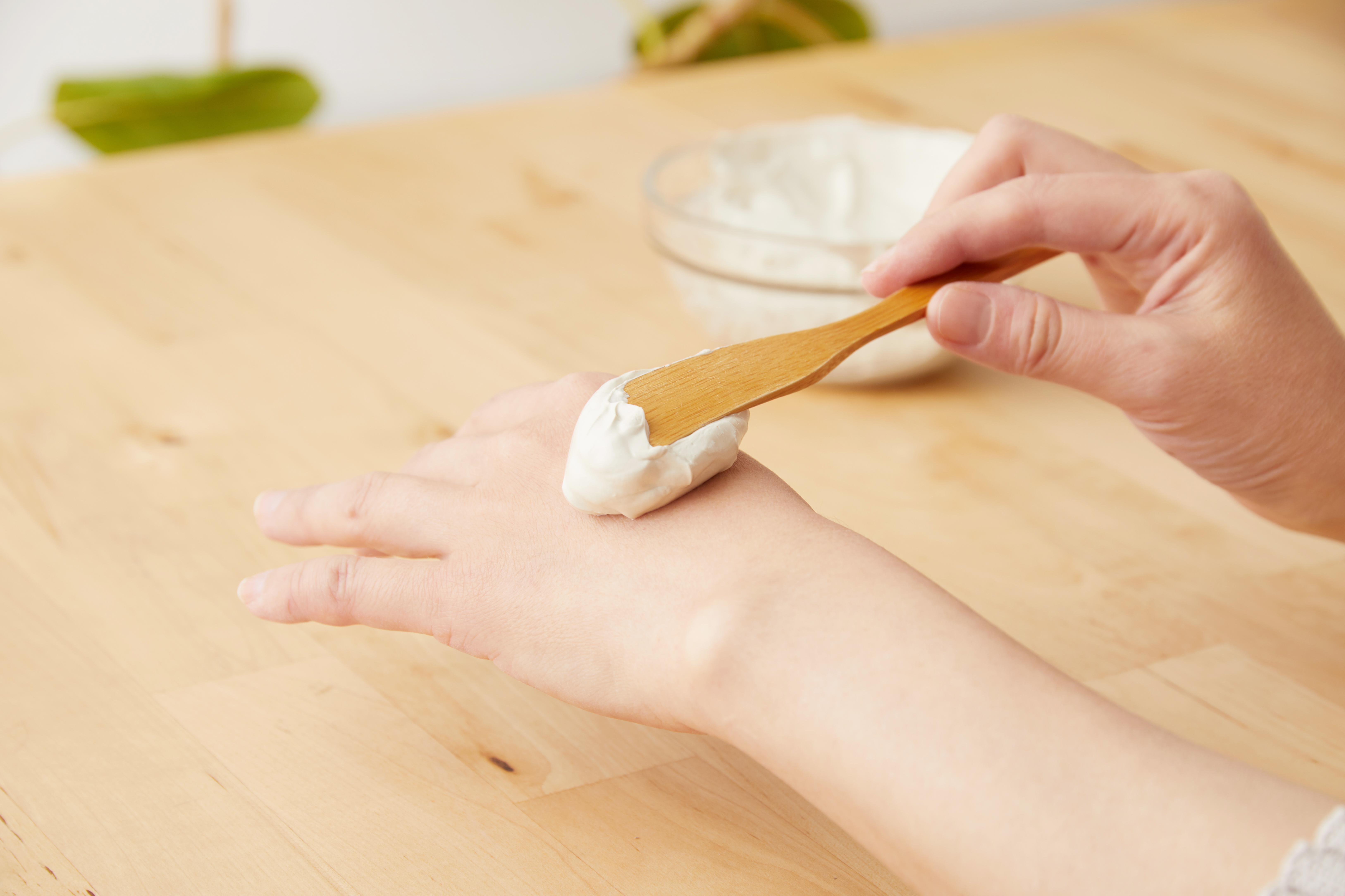 竹スパチュラでクレイペーストを手に塗布する様子